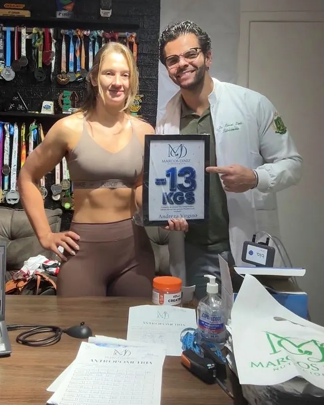 Paciente do Dr. Marcos Diniz recebendo uma placa de resultado