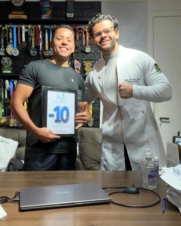 Paciente do Dr. Marcos Diniz recebendo uma placa de resultado