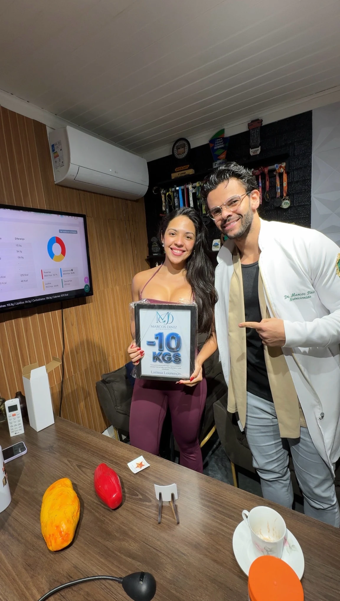 Paciente do Dr. Marcos Diniz recebendo uma placa de resultado